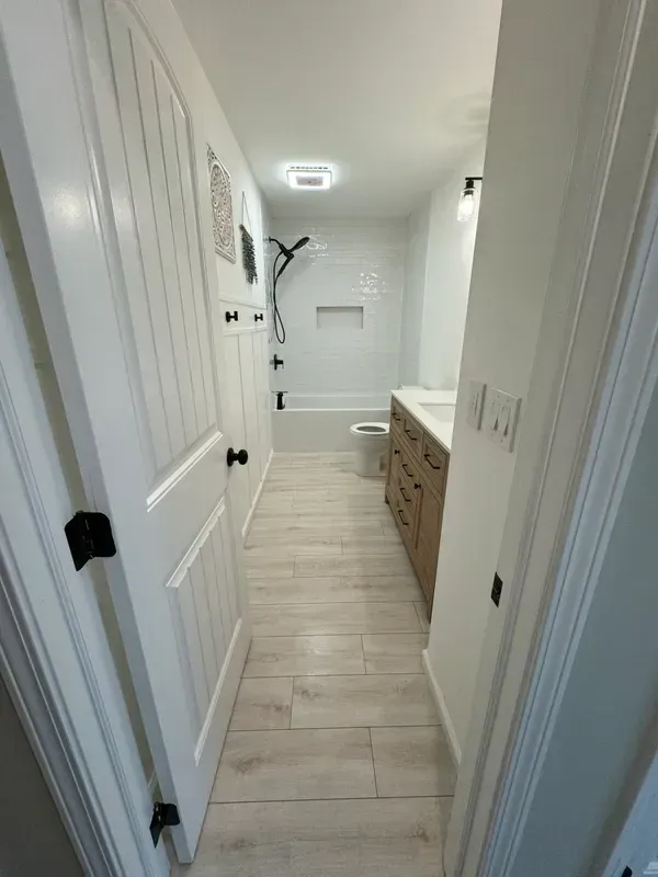 A bathroom with a walk in shower , sink , toilet and bathtub.