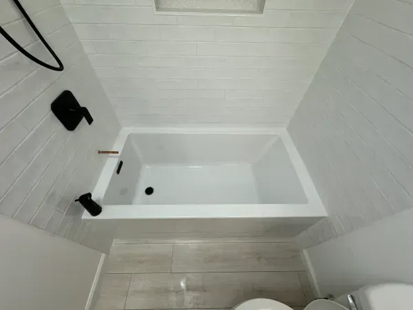 A bathroom with a bathtub and a toilet.