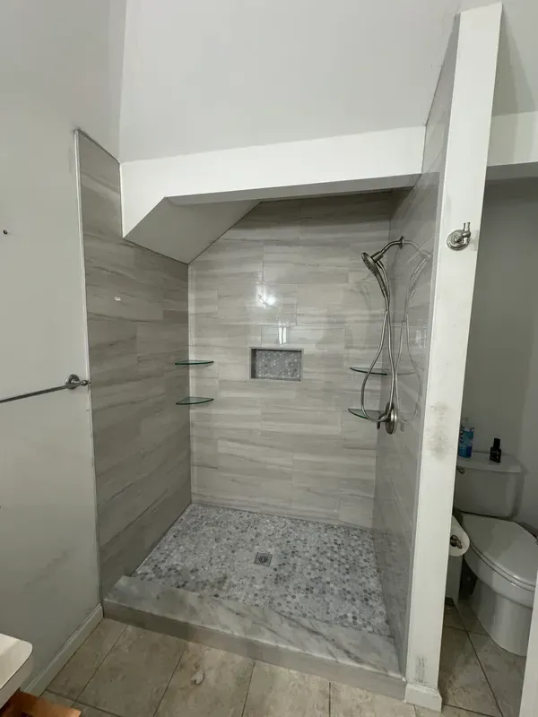 A bathroom with a walk in shower and a toilet.