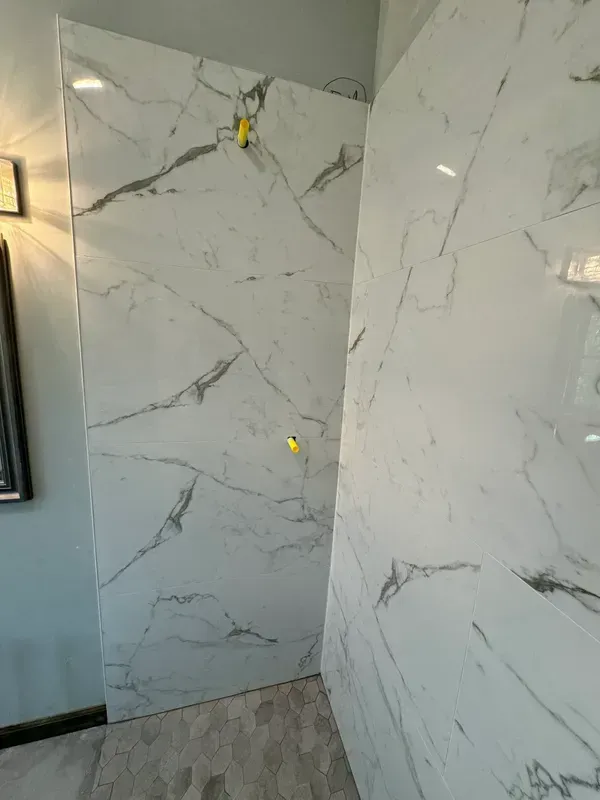 A bathroom with marble tiles on the wall and floor.