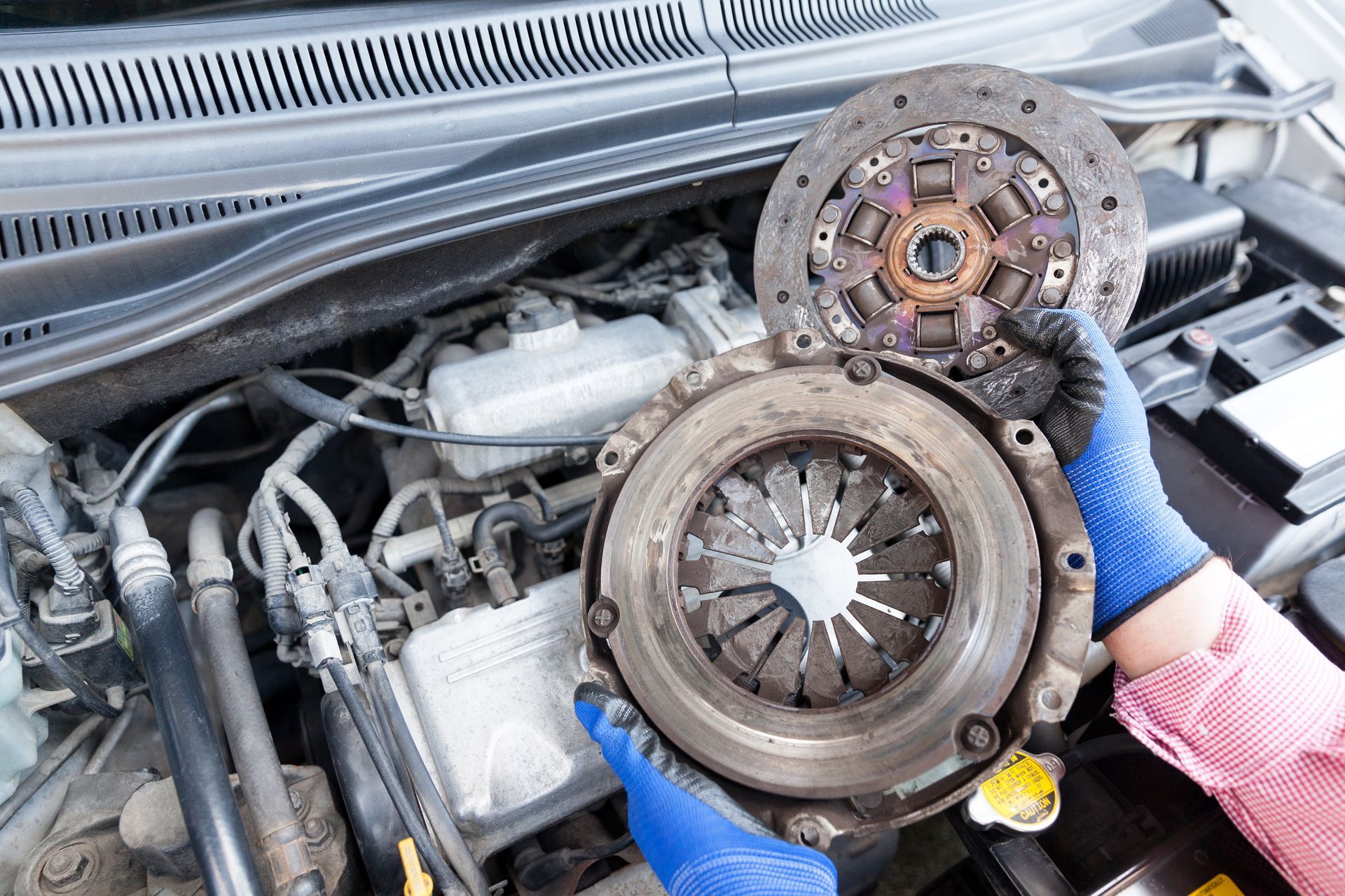 Close-up of a used clutch disc and pressure plate for a professional auto clutch replacement.