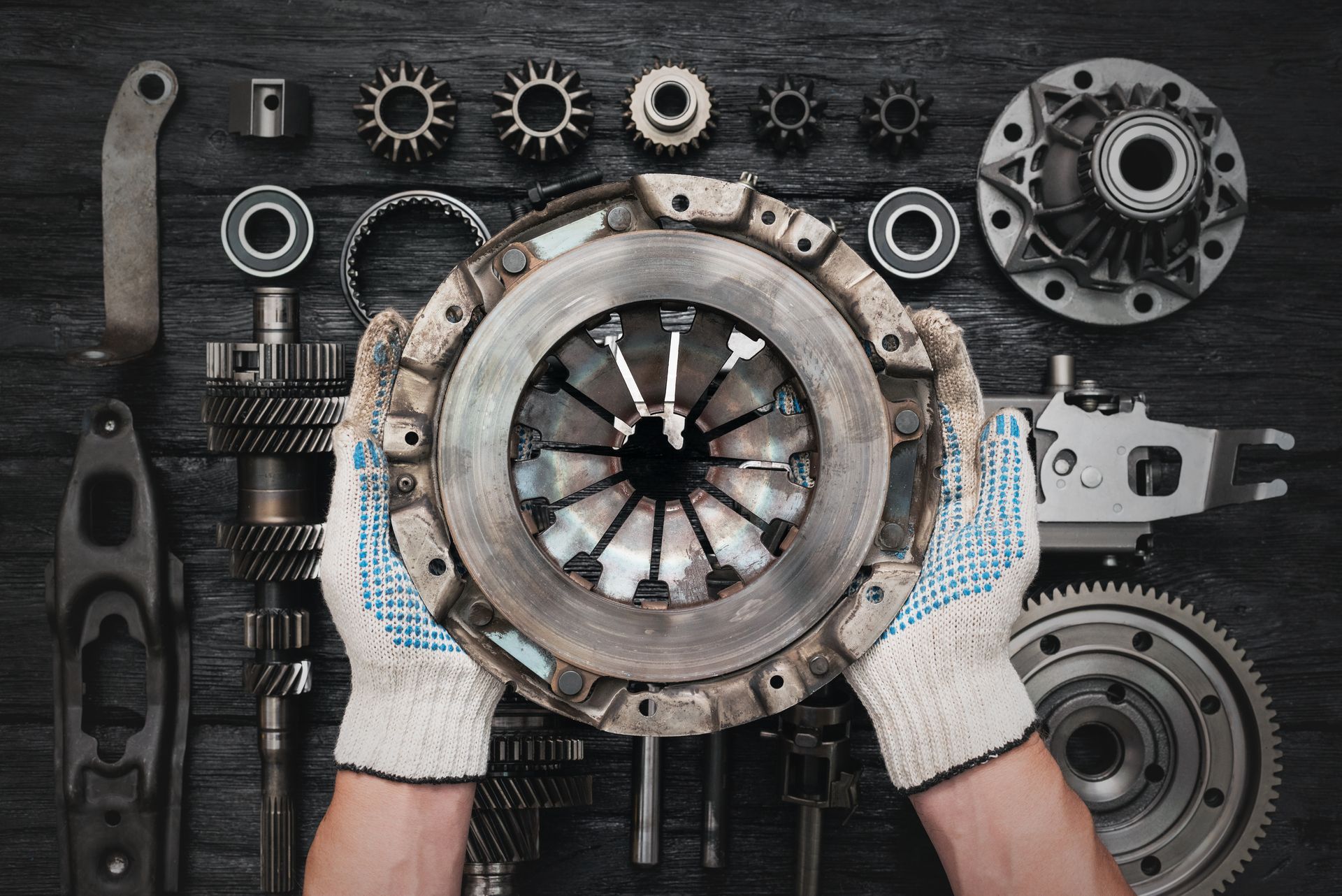 Mechanic holding a pressure plate for a professional auto clutch replacement service.