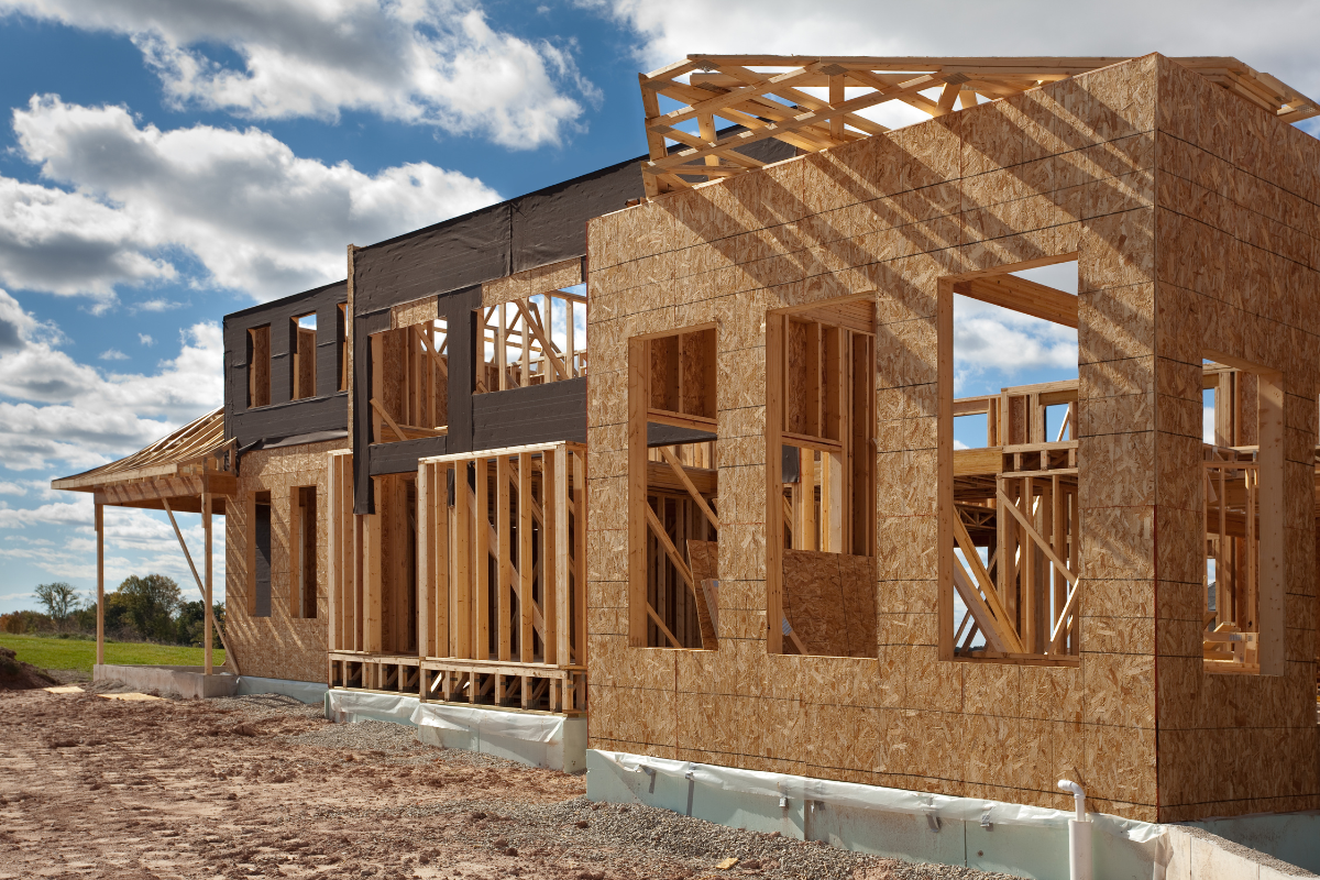 House frame under construction with exposed wooden studs and sheathing.