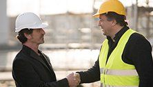 Construction worker and business man shaking hands — Property Specialist in Meridian, MS