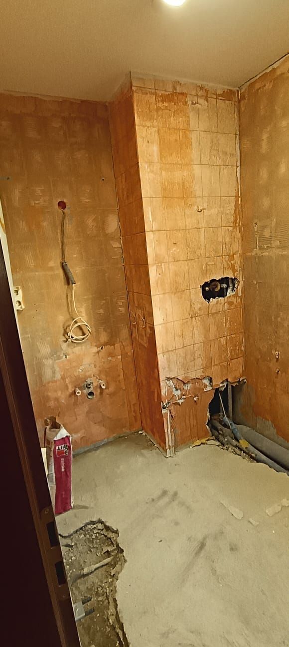 A bathroom under construction with brick walls and a concrete floor.