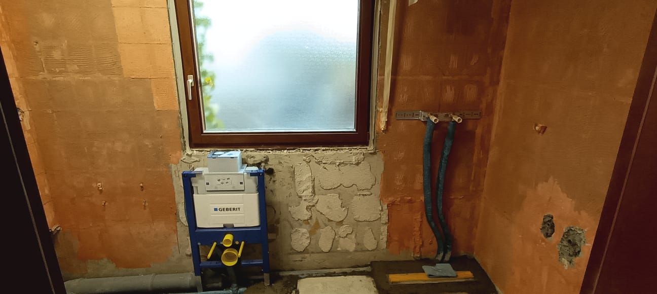 A bathroom under construction with a toilet and a window.