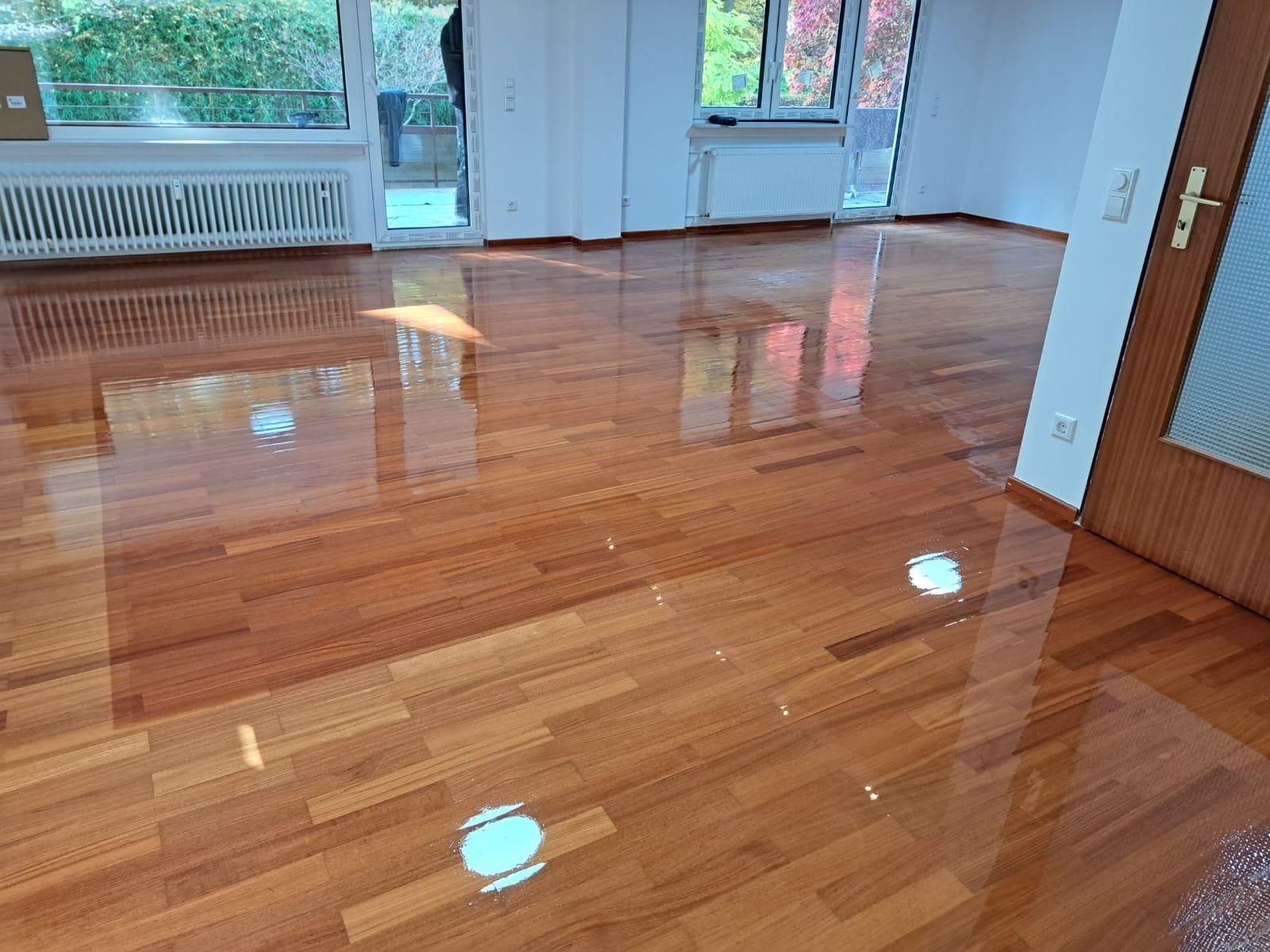 A living room with a wooden floor and a door.