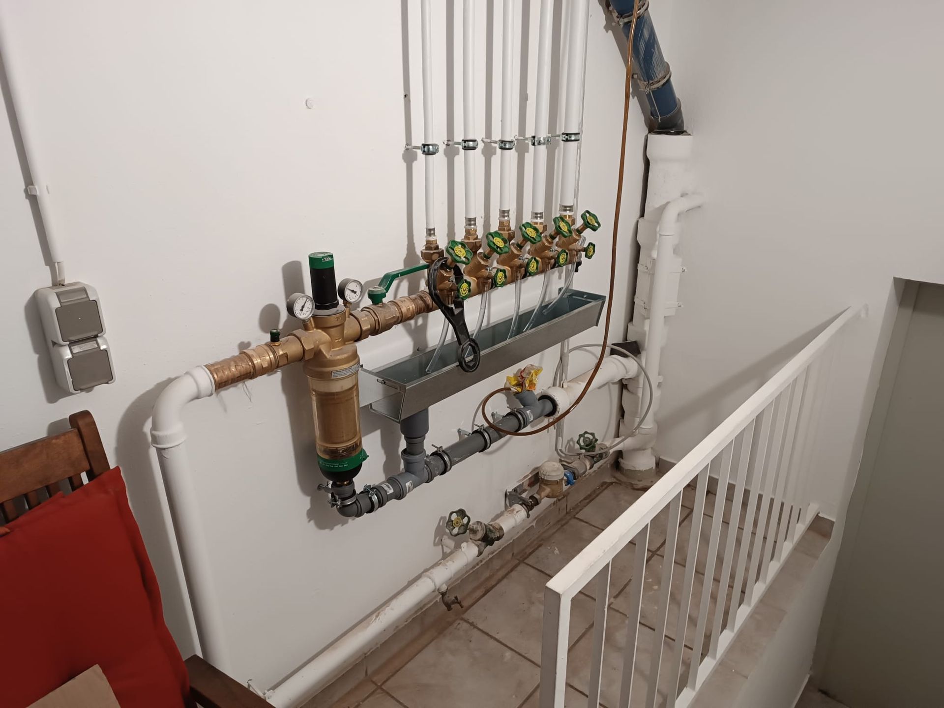 A room with a lot of pipes hanging on the wall.