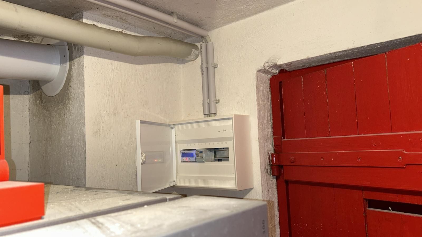 There is a red door and a box on the wall.