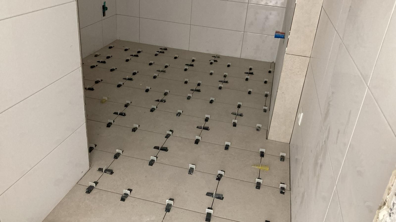 A bathroom with a lot of tiles on the floor.