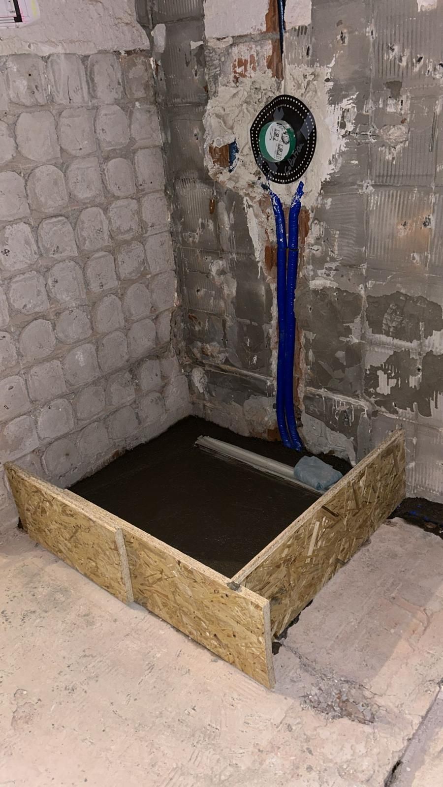 A shower stall is being built in a bathroom.