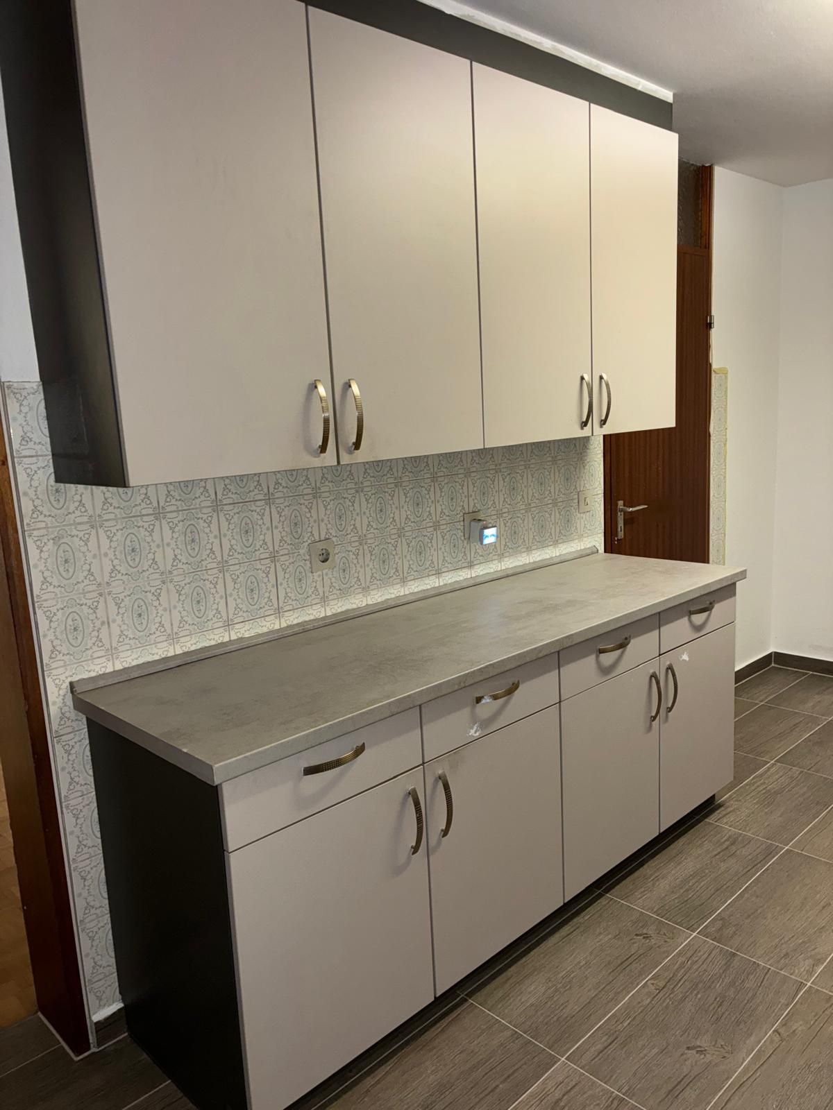 Kitchen cabinets: Upper and lower cabinets in light gray with dark gray trim and countertop.