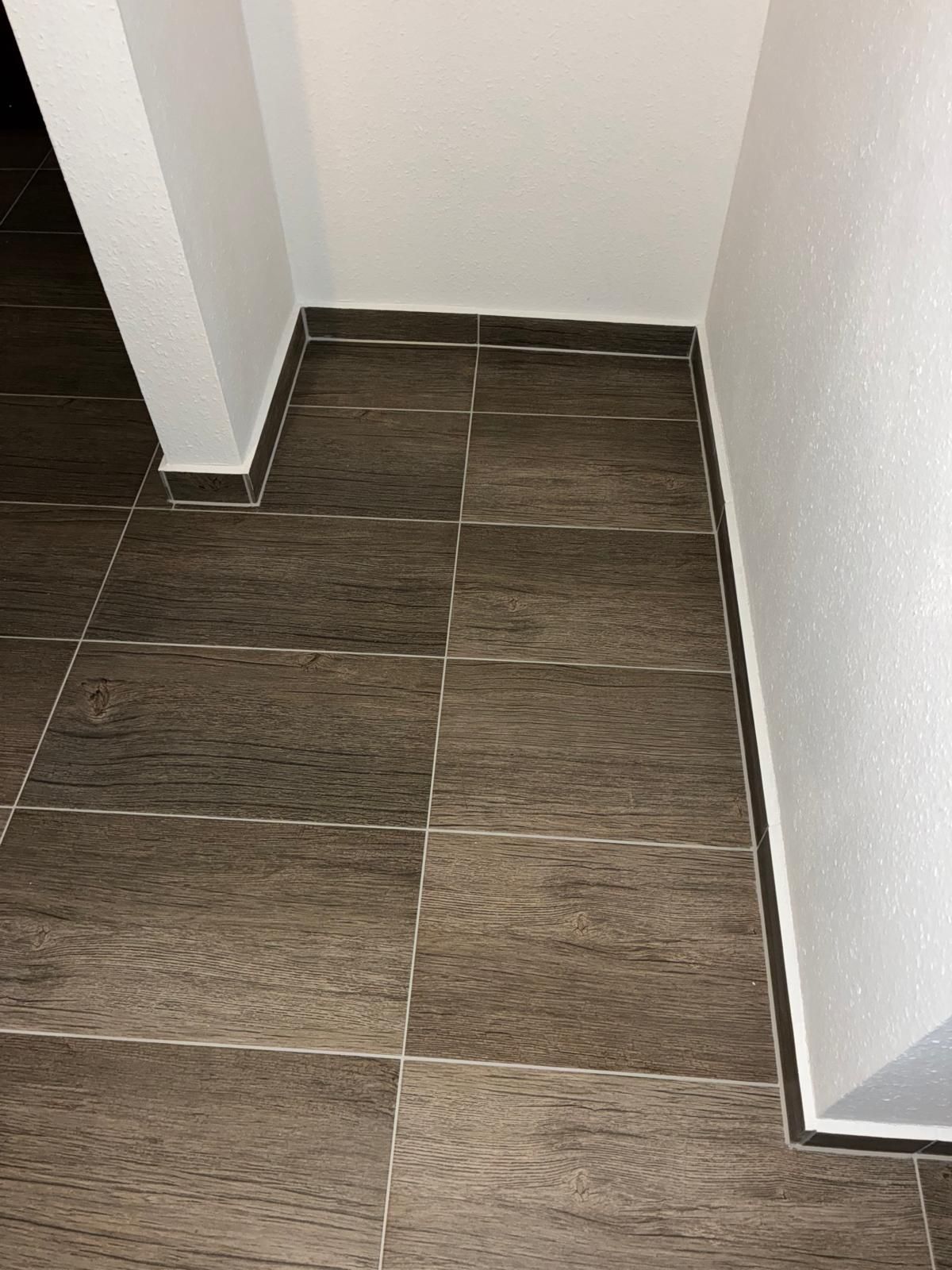 Brown tiled floor with white walls and trim.