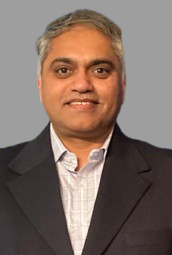 A man in a suit and white shirt is smiling for the camera.