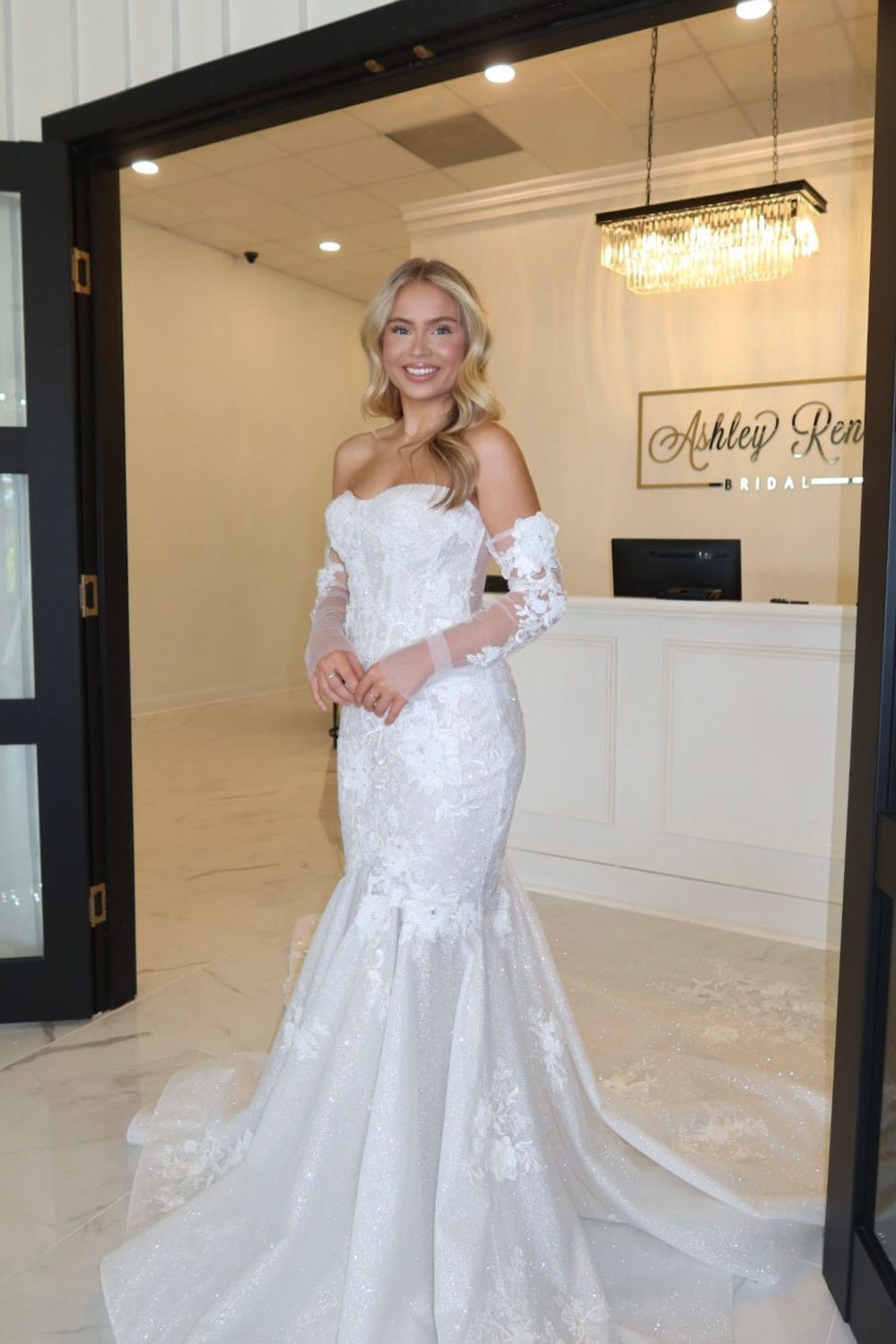 A woman in a wedding dress is standing in front of a door.