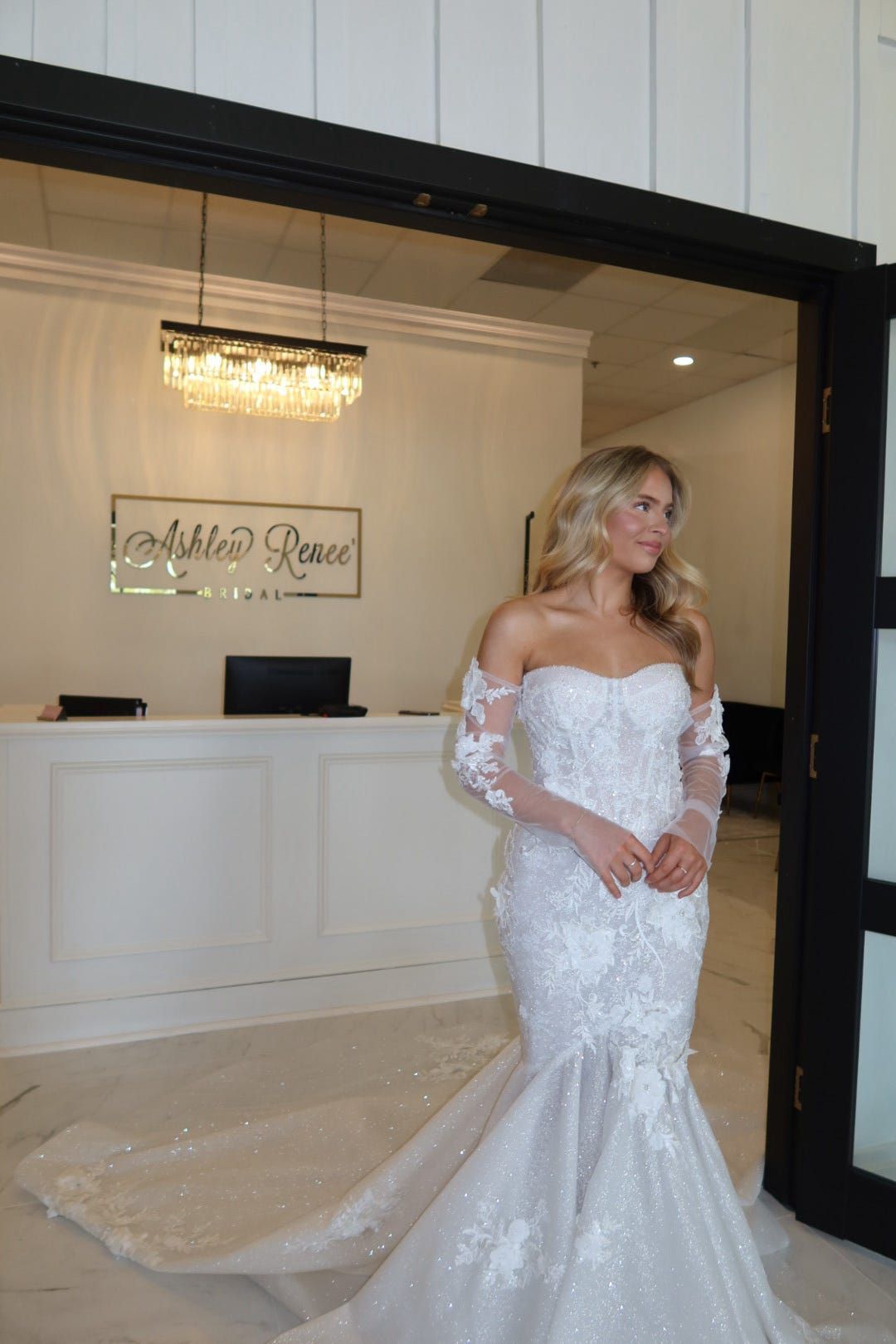A woman in a wedding dress is standing in front of a reception desk.
