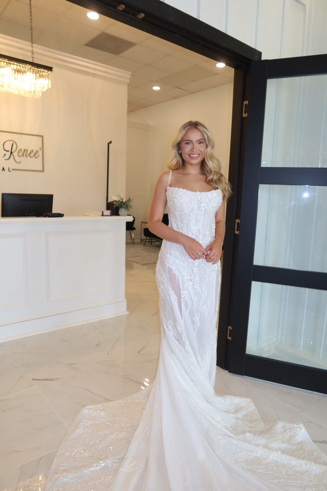 A woman in a wedding dress is standing in front of a door.