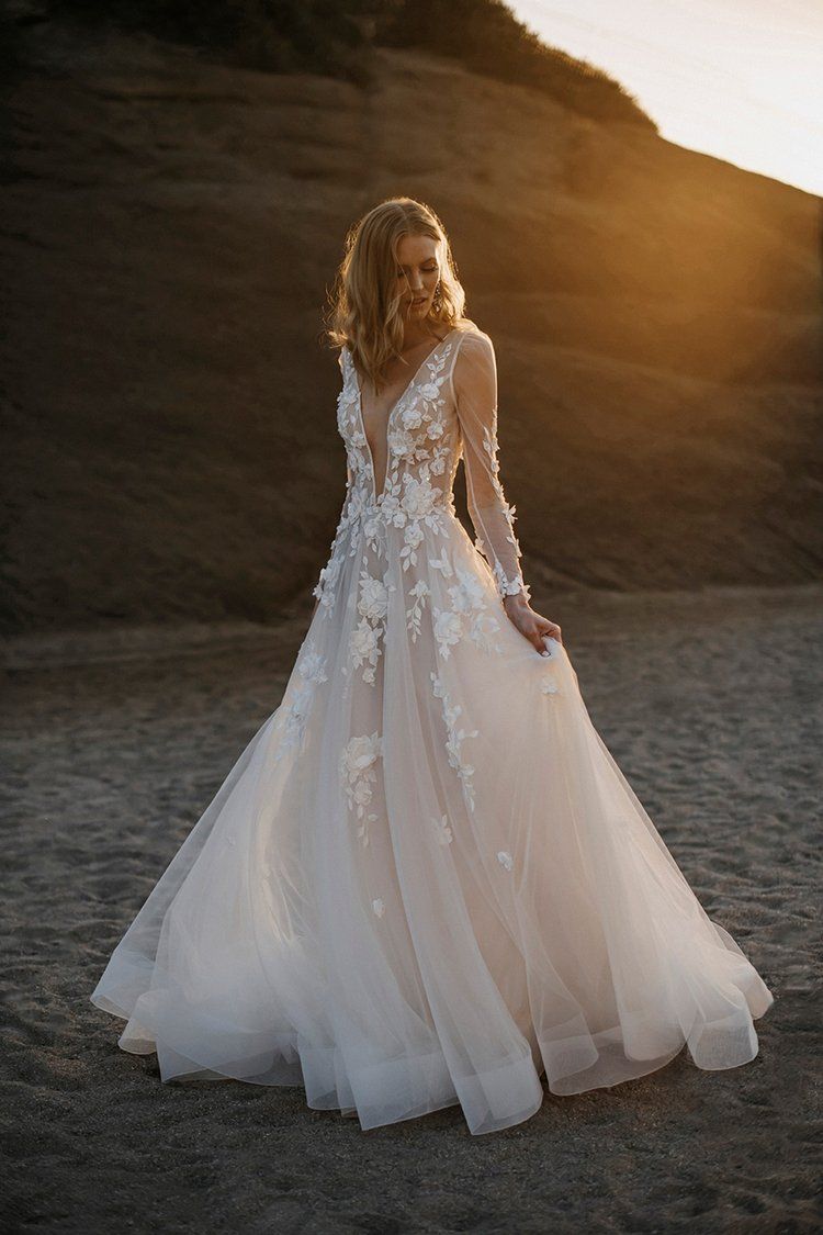 A woman in a wedding dress is standing in the dirt.