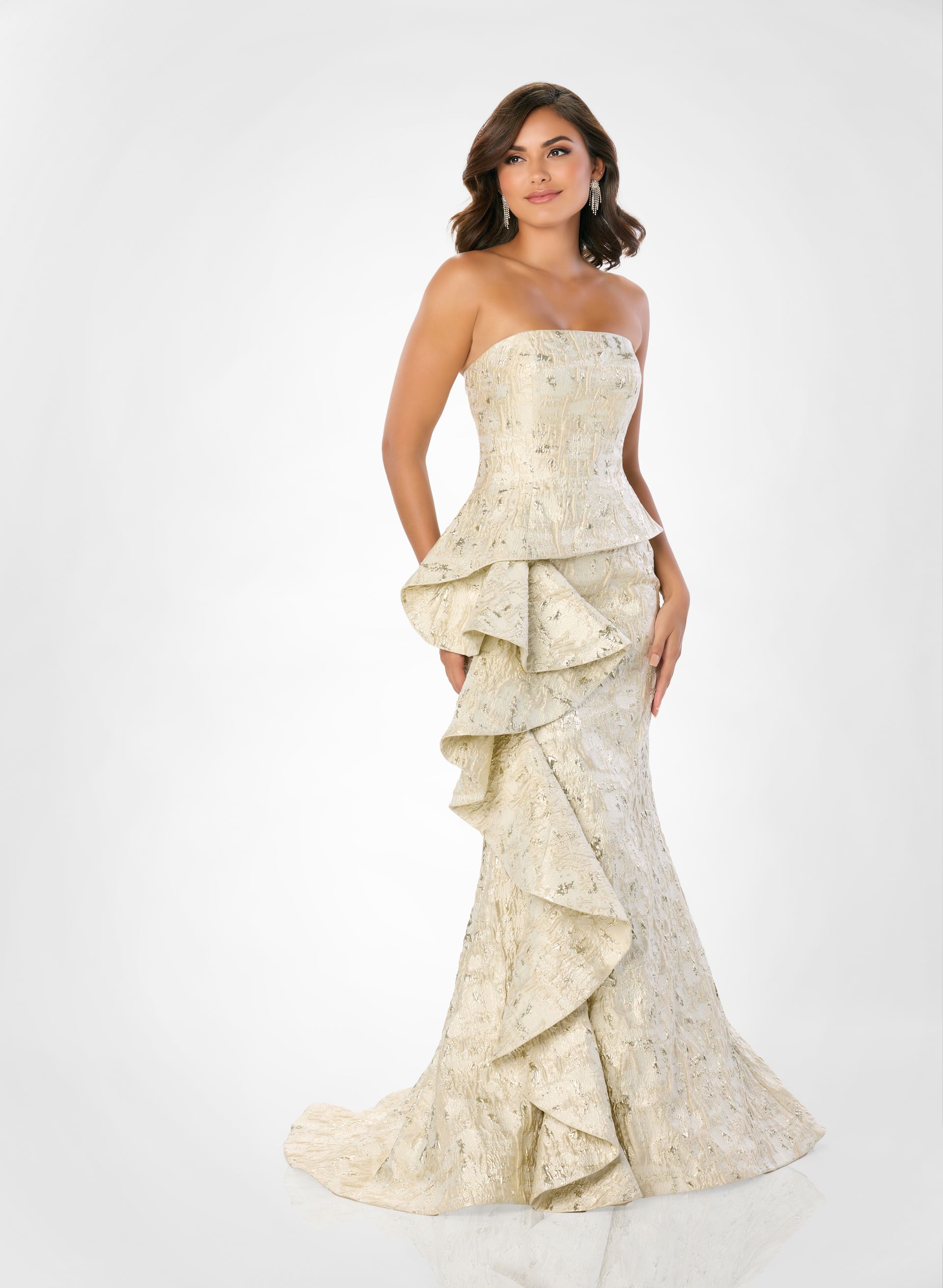 A woman is wearing a strapless gold dress with ruffles.
