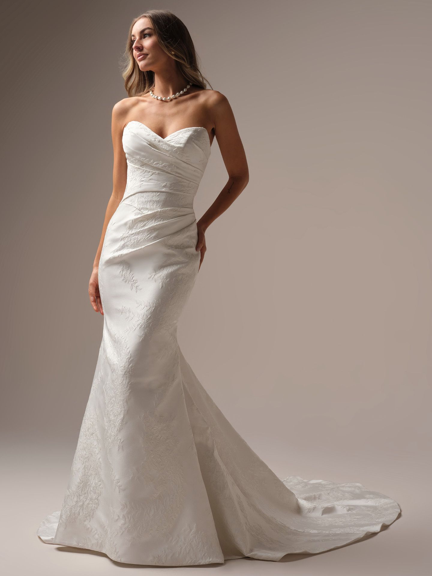 Woman in a strapless white wedding dress with a mermaid silhouette.