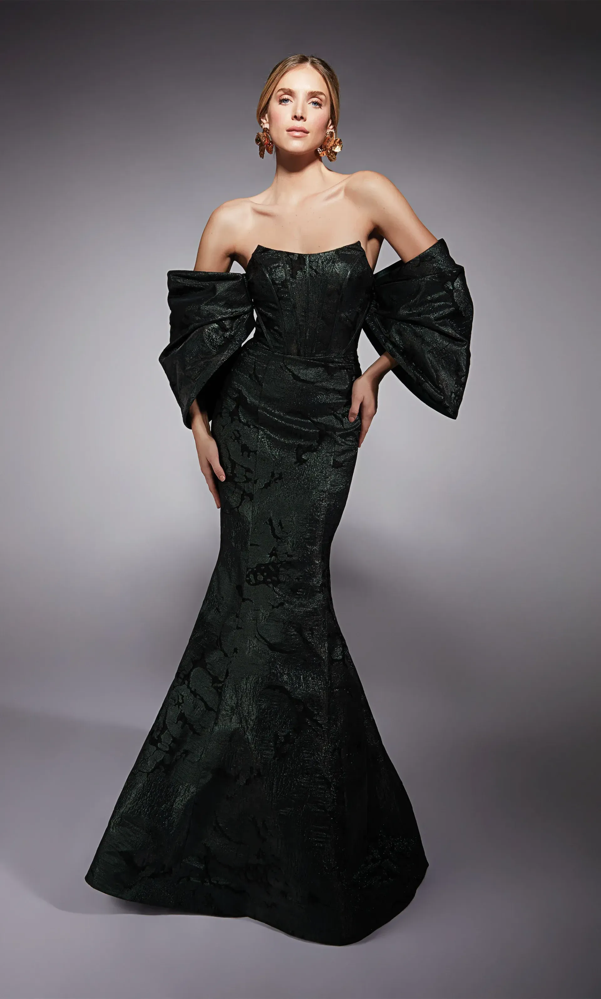 A woman is wearing a long black dress with ruffled sleeves.