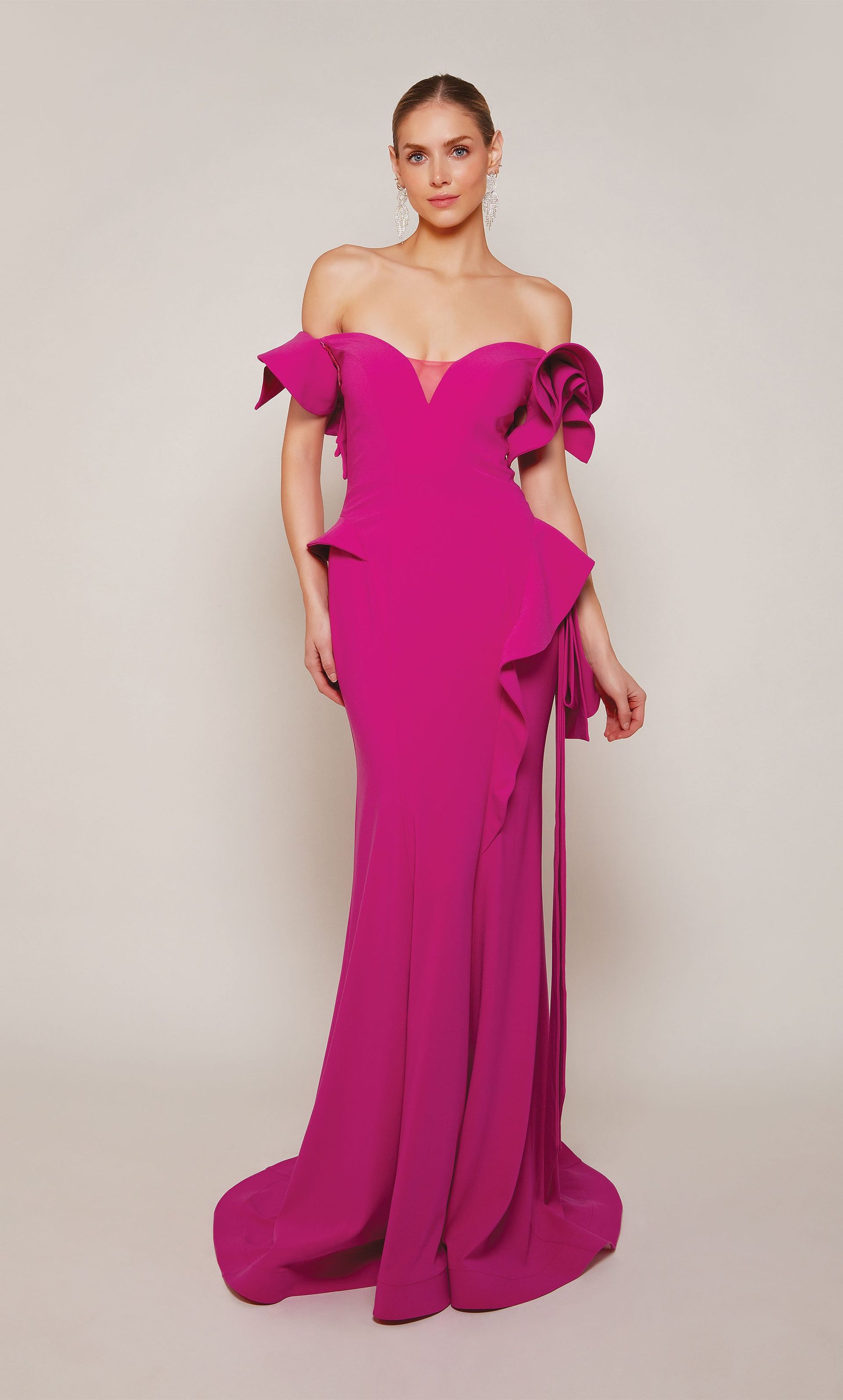 A woman is wearing a long pink dress with ruffles on the sleeves.