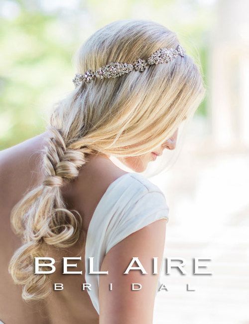 A woman in a wedding dress is wearing a headband in her hair.