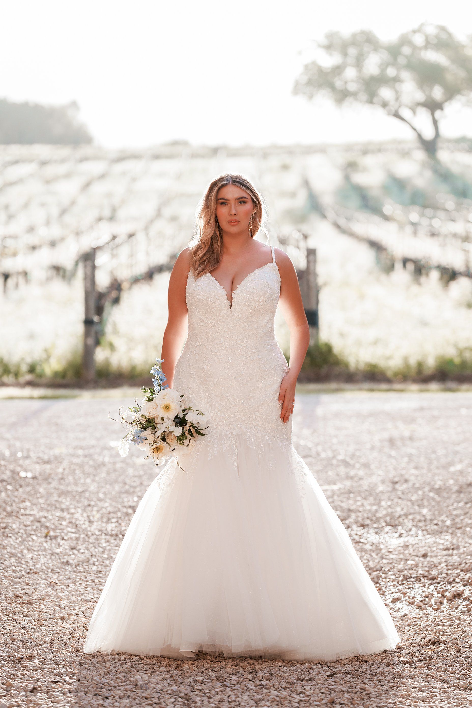 A woman in a wedding dress is holding a bouquet of flowers.