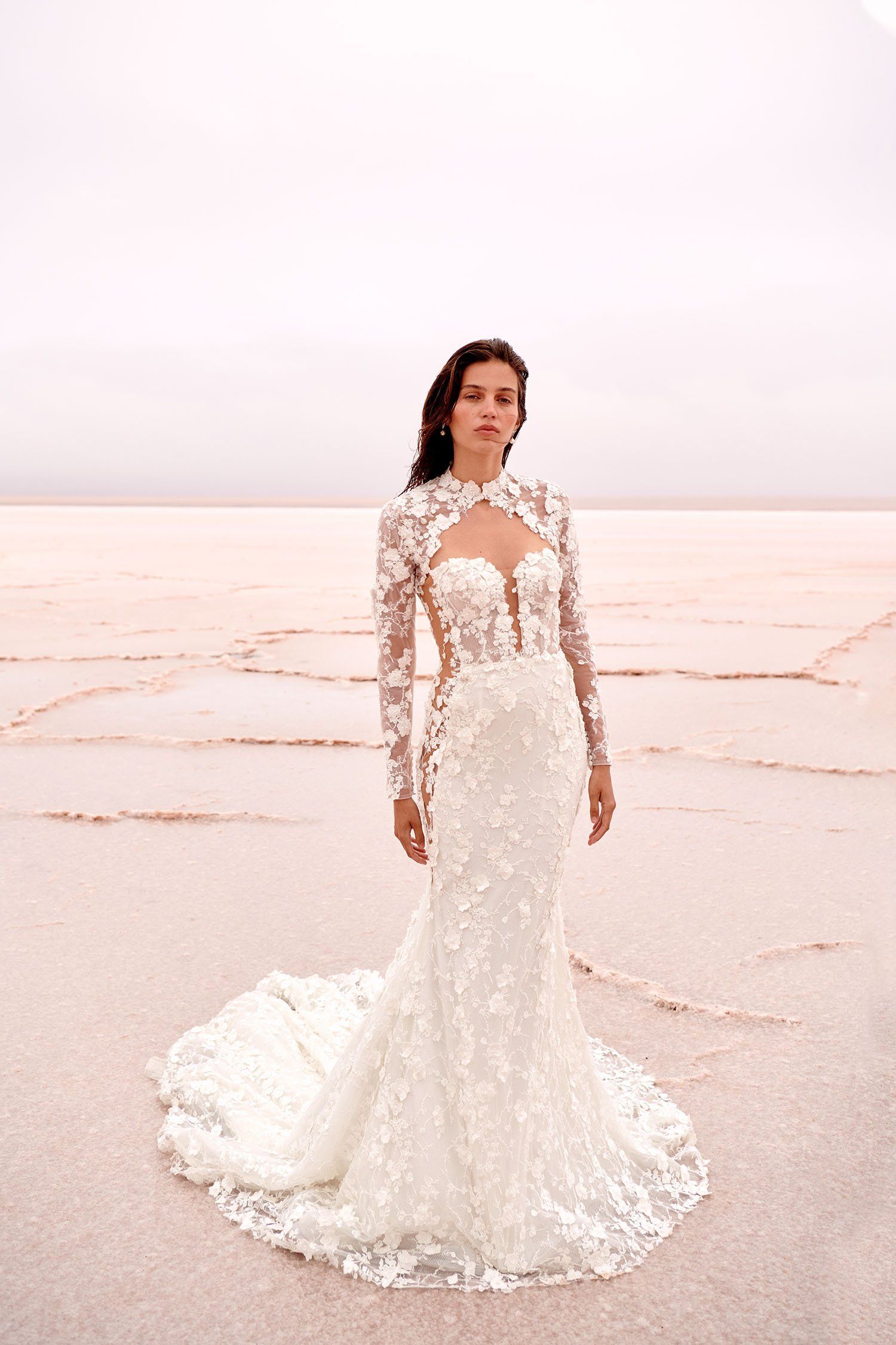 A woman in a wedding dress is standing on a beach.