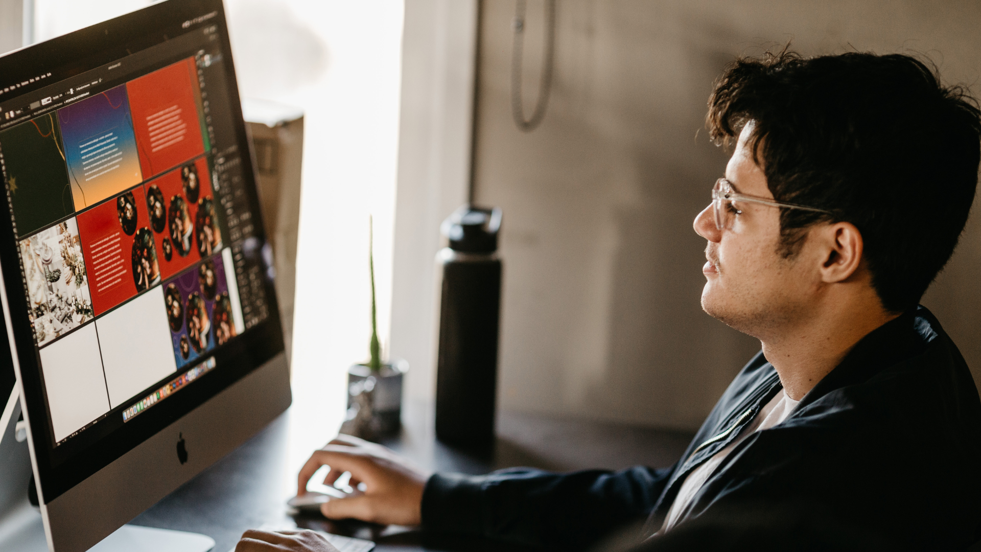A man is sitting at a desk using a computer.