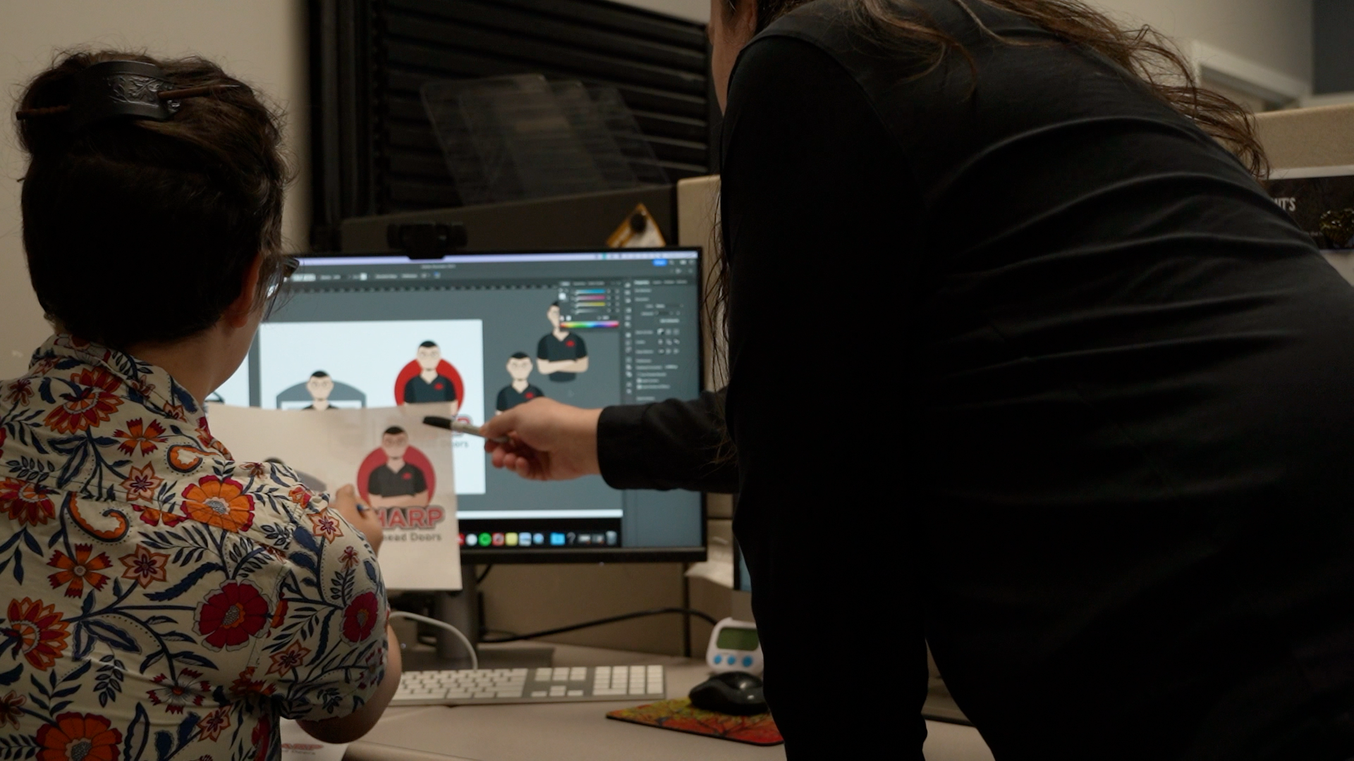 A man and a woman are looking at a computer screen.
