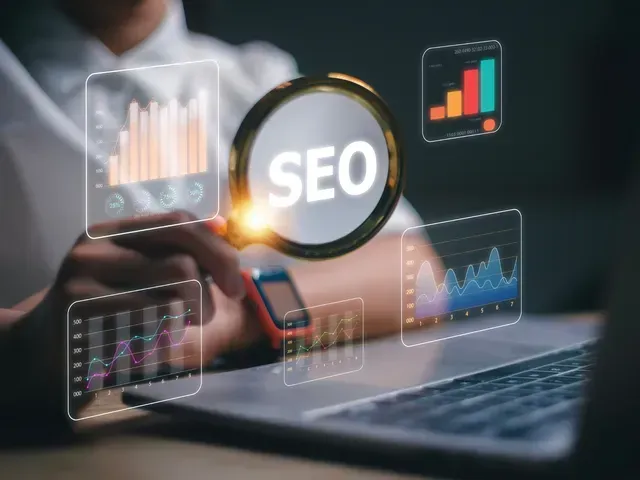 A person is looking at a laptop with a magnifying glass.