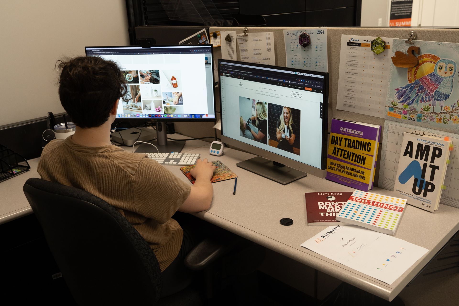 A man is sitting at a desk in front of two computer monitors.