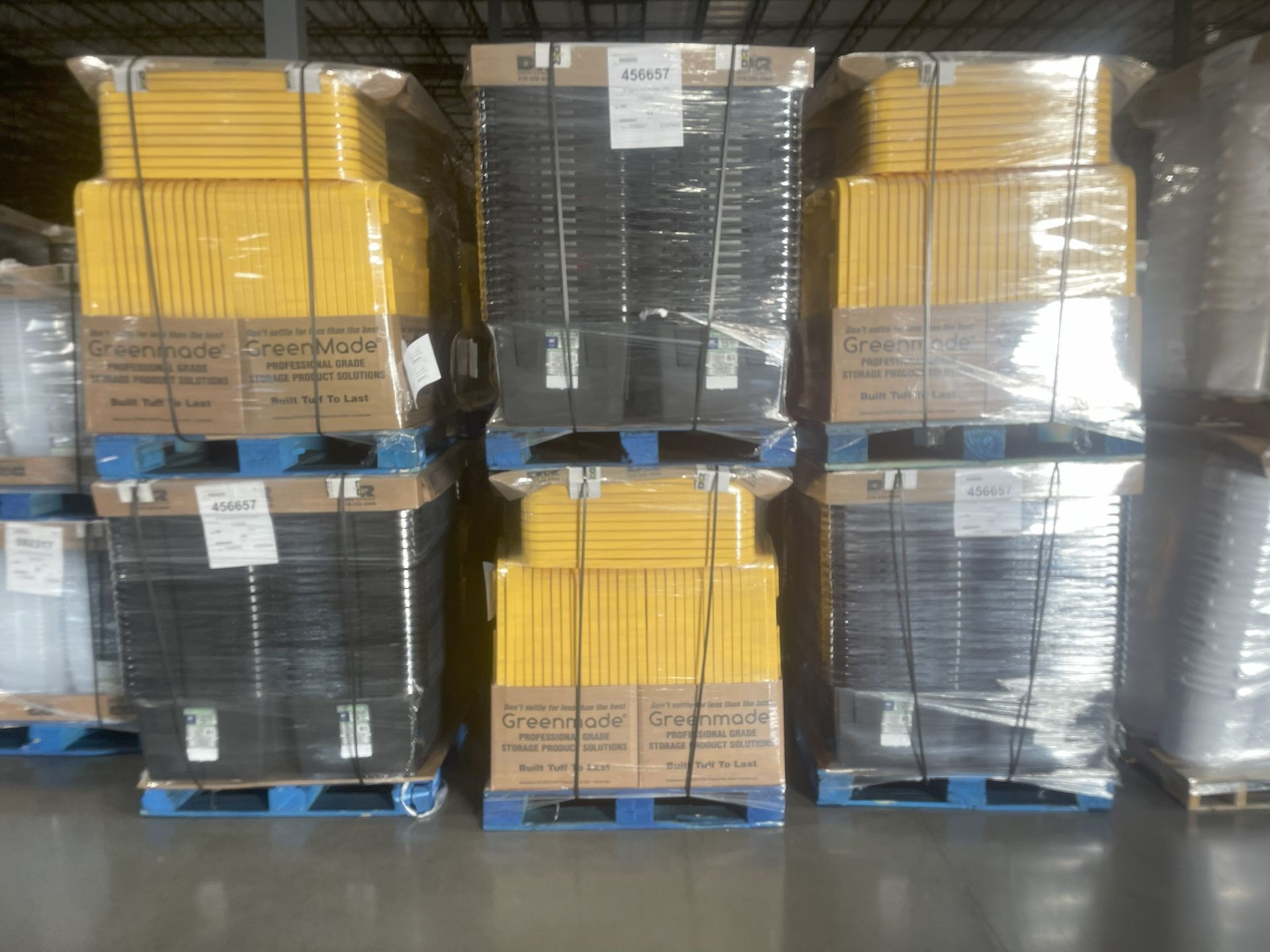 Pallets stacked with wrapped boxes, yellow and black, inside a warehouse.