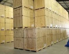 Stacked wooden crates in a warehouse, filling the space, ready for transport or storage.