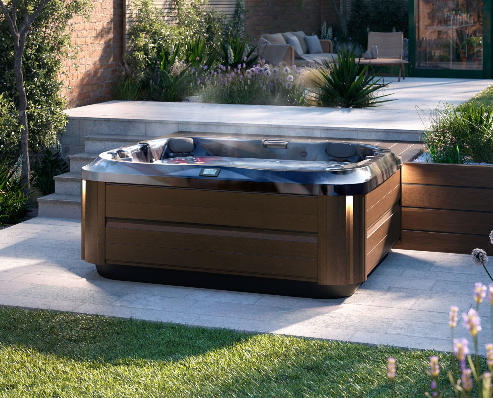 Hot tub on a patio. Wooden facade, steps up to seating area, green grass surrounds.