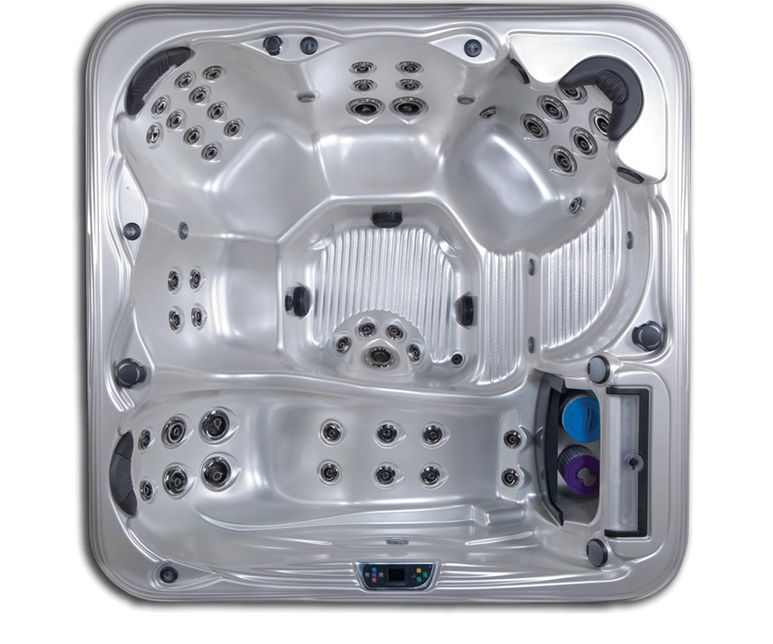 Overhead view of a silver hot tub with molded seating, jets, and a control panel.