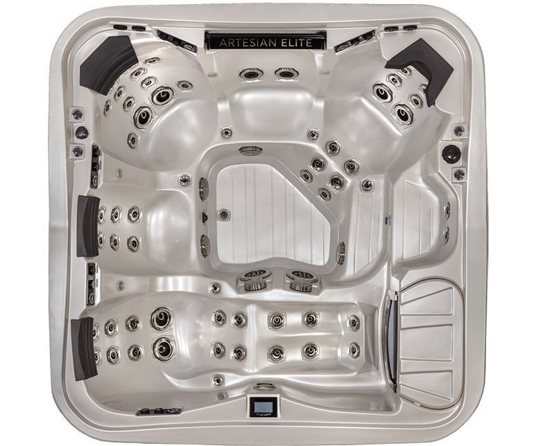 Overhead view of a light-colored hot tub with multiple seating areas and jets, the brand name