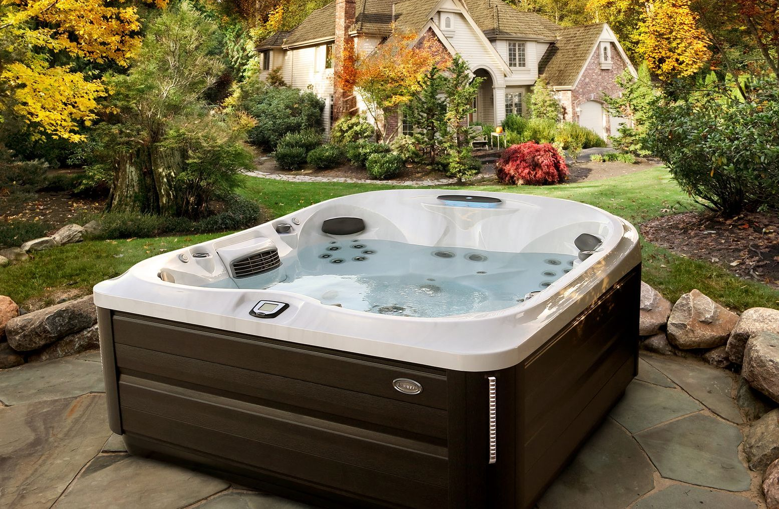 Hot tub on a patio with a house in the background; autumn foliage.