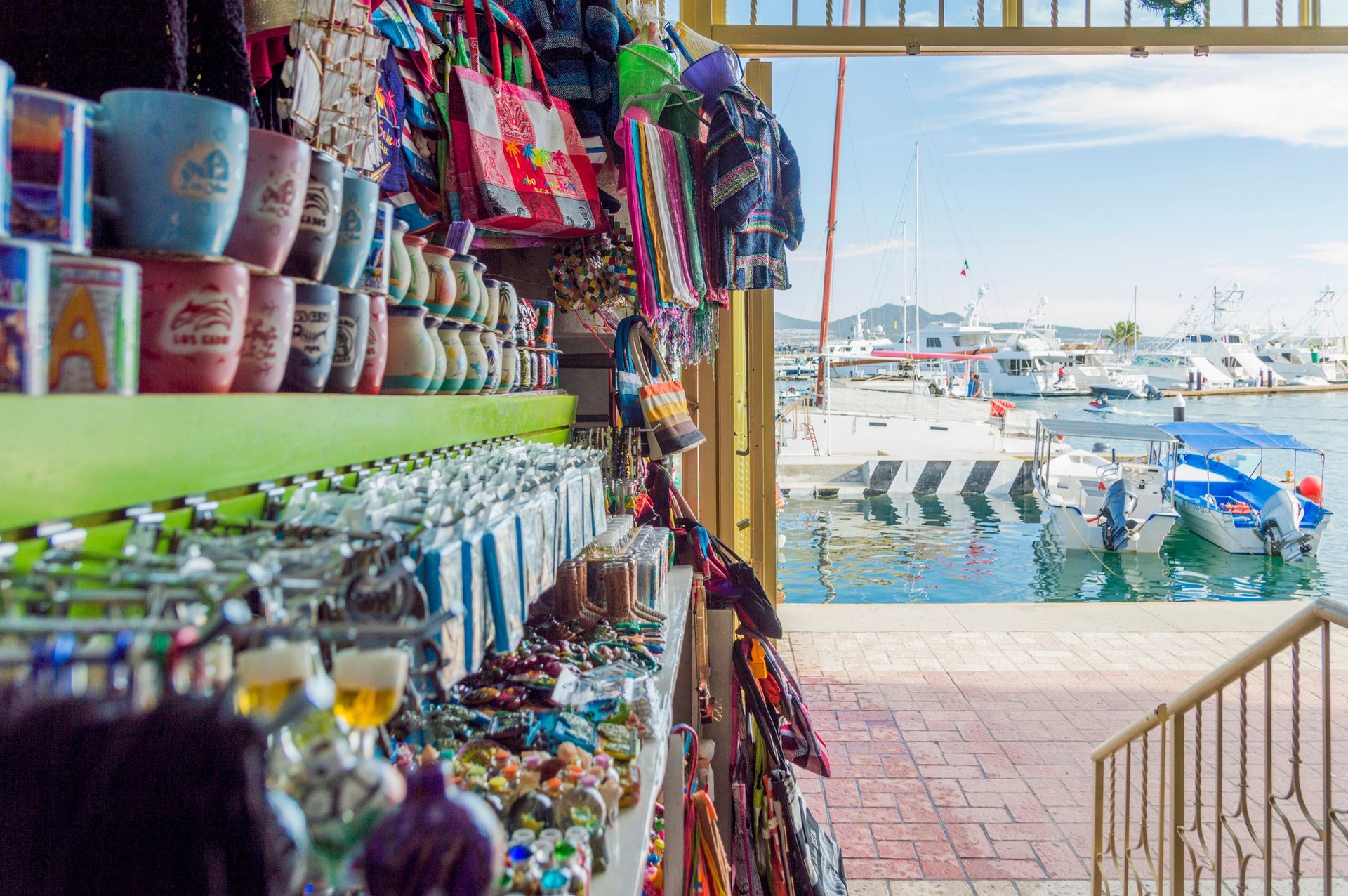 A store filled with lots of souvenirs and a boat in the background.