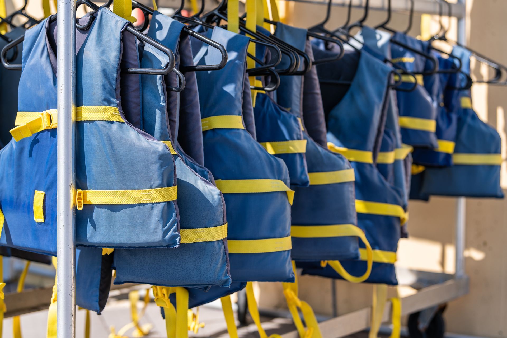 A row of life jackets hanging on a rack.