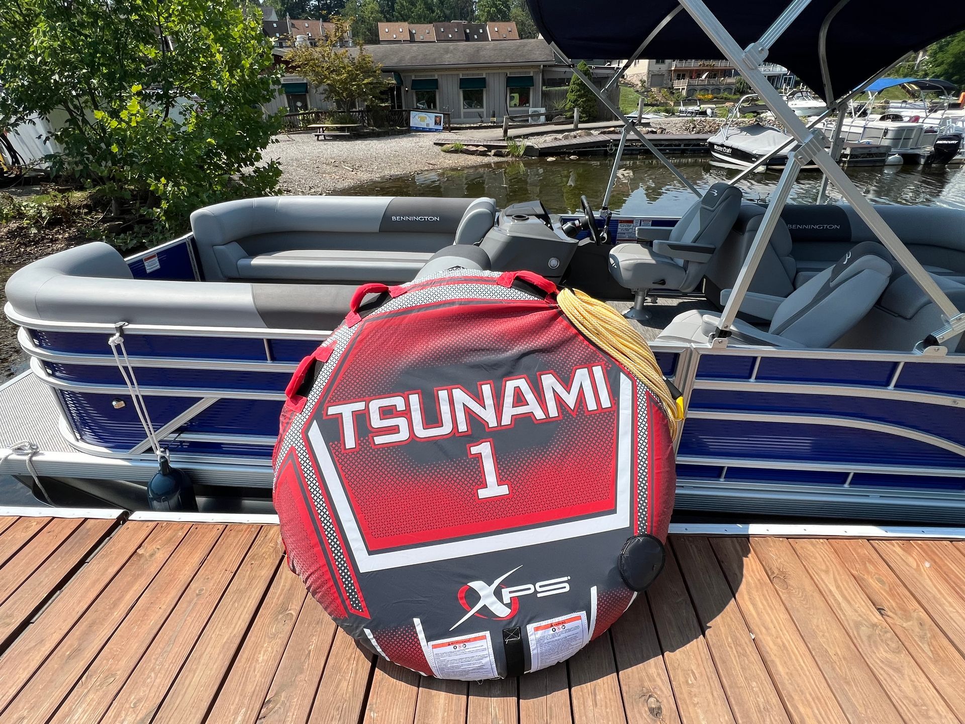 A pontoon boat with a green canopy is floating on a river