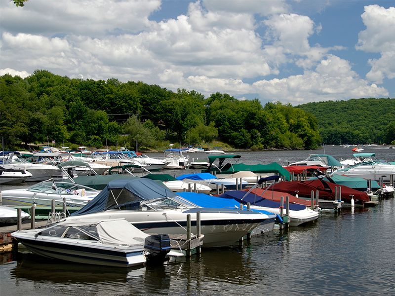 A row of boats are docked at a marina