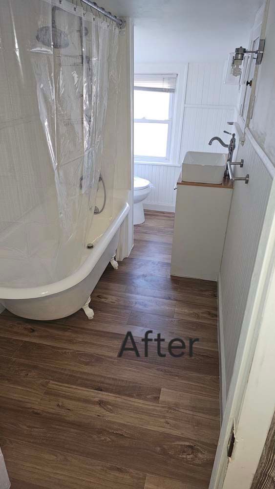Bathroom with clawfoot tub, wood-look floor, pedestal sink, and shower curtain. 
