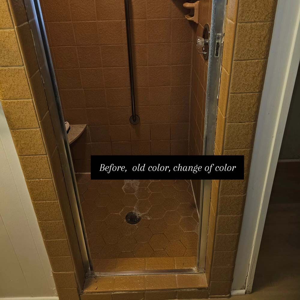 Brown tile shower with glass door.