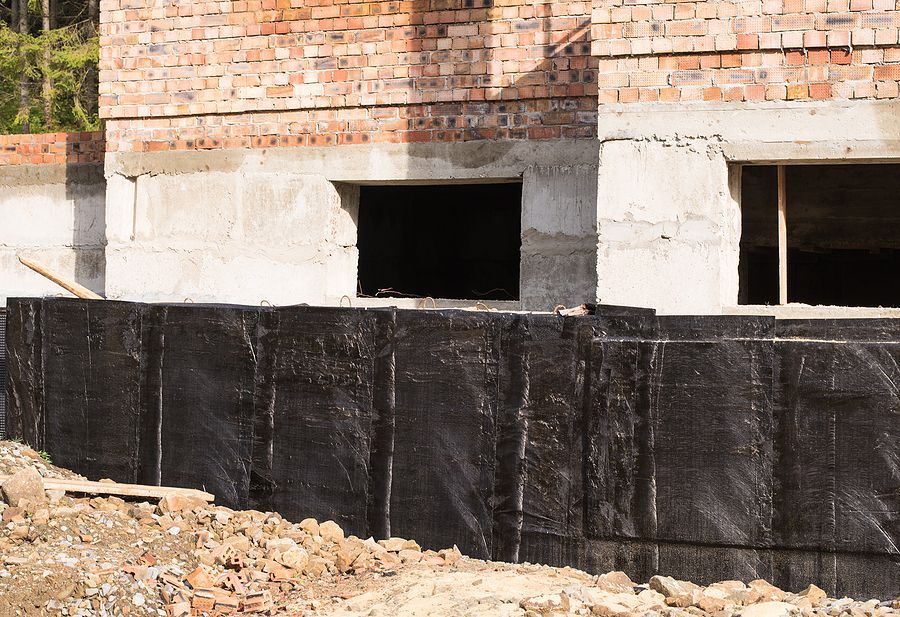 a building under construction with a brick wall and two windows