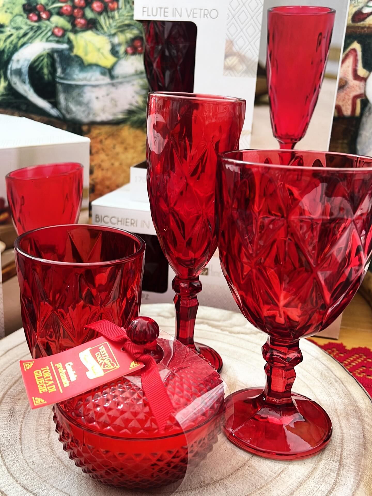 In mostra, bicchieri rossi, tra cui calici, una flûte da champagne e un bicchiere.