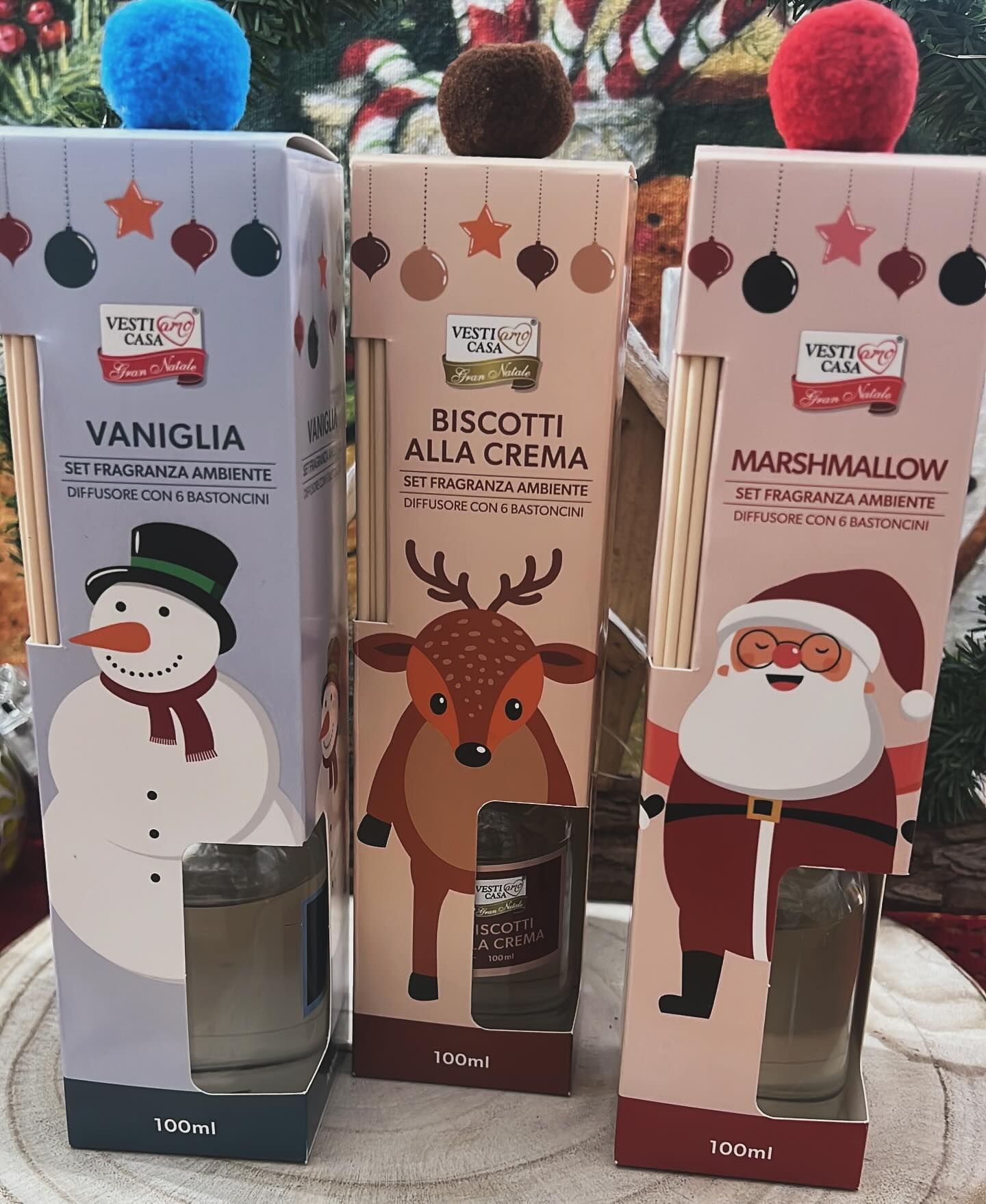 Tre diffusori di fragranza a bastoncini a tema natalizio: vaniglia, biscotti alla crema e marshmallow, con personaggi festivi e decorazioni colorate.