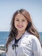 Amber is wearing a black jacket and smiling for the camera.