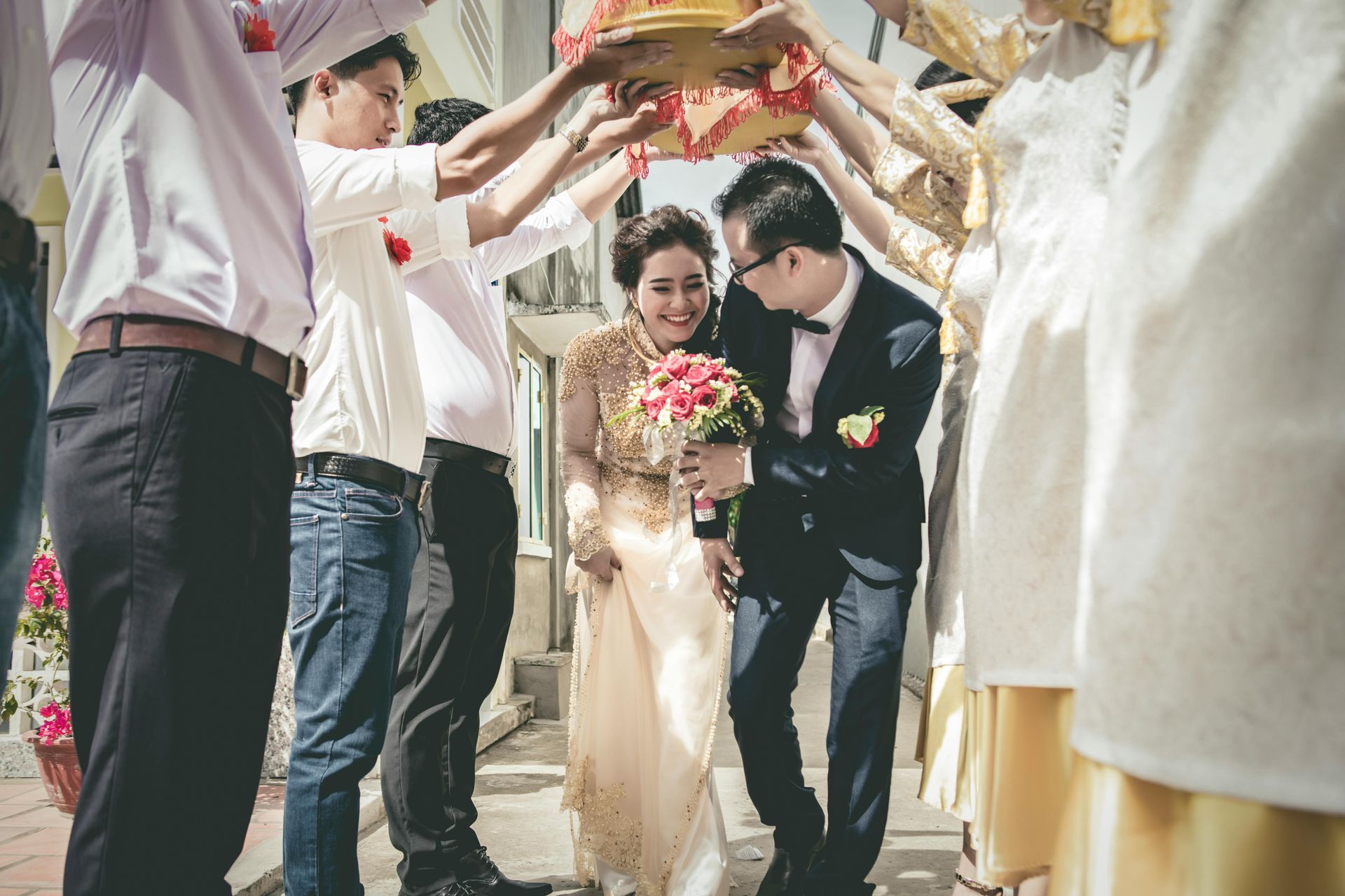 A bride and groom are being escorted by their wedding party.